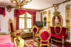 a bedroom with gold and red chairs and a bed at Königreich Romkerhall in Schulenberg im Oberharz