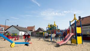 a playground with a bunch of playground equipment in the sand at Chaletparc Krabbenkreek Zeeland - Chalet 94 in Sint Annaland