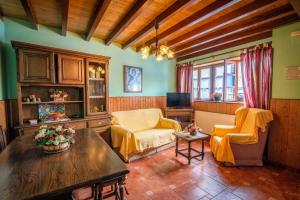 a living room with yellow chairs and a table at Casa de Aldea el Ferreirón in Castropol