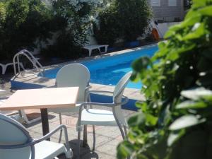 a table and chairs next to a swimming pool at George apartments in Kallithea Halkidikis