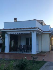 a white house with a patio with chairs on it at Anna House Palouri in Paliouri