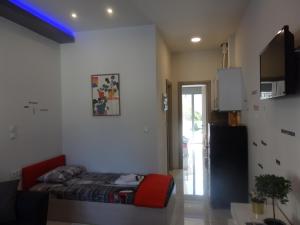 a bedroom with a bed and a red chair at George apartments in Kallithea Halkidikis