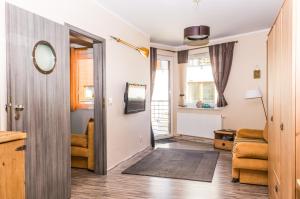 a hallway with a living room with a door and a mirror at Apartament Bosmański in Puck