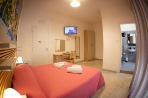 sypialnia z czerwonym łóżkiem i 2 ręcznikami w obiekcie B&B Salerno Center w mieście Salerno