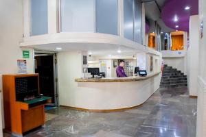 a man standing at a counter in a hospital lobby at Hotel San Francisco Centro Histórico in Mexico City