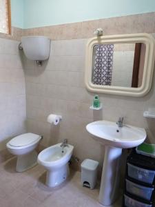 bagno con lavandino, servizi igienici e specchio di Appartamento Giusy a Foligno