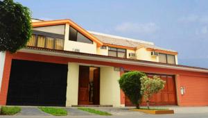 una casa roja y blanca con garaje en Monterrico Hotel Perú, en Lima