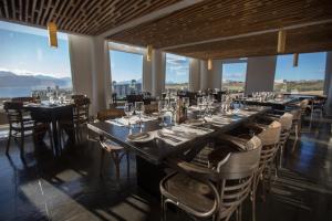 a dining room with tables and chairs and windows at Remota Patagonia Lodge in Puerto Natales +37 photos