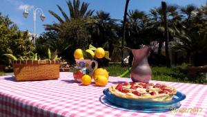 ein Picknicktisch mit einer Pizza und einer Vase darauf in der Unterkunft Villa Ida in Bari in Bari