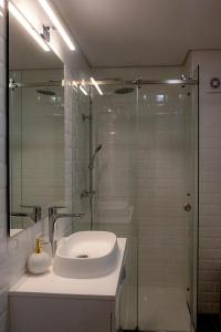 a bathroom with a sink and a glass shower at Apartment Trindade Way in Porto