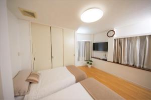1 dormitorio con 1 cama y reloj en la pared en SHINJUKU 5-ROOM Family house, en Tokio