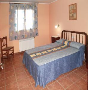 バルデロブレスにあるApartamentos Casa Ferrásのベッドルーム1室(ベッド1台、椅子、窓付)