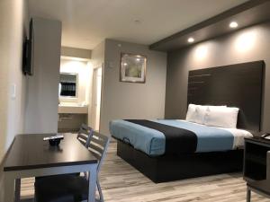 ヒューストンにあるCrystal Inn Downtownのベッドとテーブルと机があるホテルの部屋