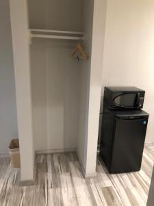 a room with a small black refrigerator and a wall at Crystal Inn Downtown in Houston