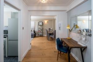 a hallway with a table and chairs and a kitchen at Homm - Hyde park 2 bedroom flat in London