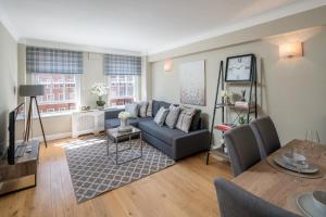 a living room with a couch and a table at Homm - Hyde park 2 bedroom flat in London