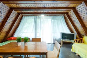 a dining room with a table and a tv in a room at Domki jak PRLu w Camp LIPNO in Stęszew