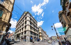 ein hohes Gebäude an einer belebten Stadtstraße mit Autos in der Unterkunft Dante Maison De Luxe in Neapel