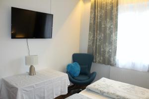 Zimmer mit einem Stuhl und einem TV an der Wand in der Unterkunft Arrahof in Harmannschlag