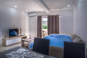 a bedroom with a bed and a tv and a couch at Apartmani Kankaras - Sea View in Tivat