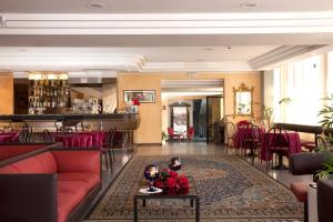 a lobby with a red couch and a table at Hotel Capitol - Bianchi Hotels in Bellaria-Igea Marina