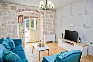 a living room with a blue couch and a tv at Vila Maestral Kotor in Kotor