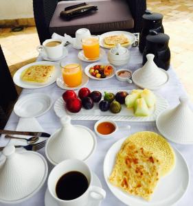 uma mesa coberta com pratos de comida e chávenas de café em Dar Fama em Tétouan