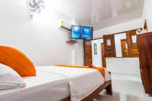 a bedroom with a bed with a tv on the wall at Casa Hotel La Mariela in Zapzurro