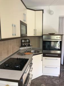 a kitchen with white cabinets and a stove top oven at Apartment Sara M in Gajac