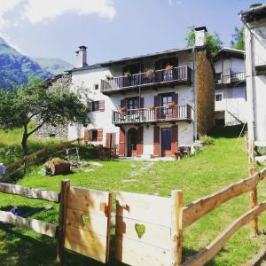 an old house with a fence in front of it at Locazione turistica Lou Bindel in Sampeire