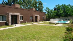 a brick building with a swimming pool in the yard at Merlo Centro Aparts in Merlo