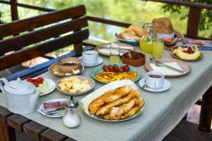 einen Tisch mit Teller mit Lebensmitteln darüber in der Unterkunft Wooden Village Resort in Ponari