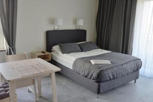 a bedroom with a bed with a table and a table at Bułgarska 59A- (1/2) piękny widok 14 piętro in Poznań
