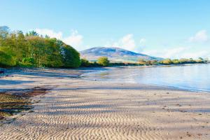 a beach with ripples in the sand next to the water at Lapwing, Skylark & Curlew Seaside Chalets in Kirkbean