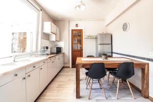 a kitchen with a wooden table and black chairs at LA VILLA JEAN-BART in Saint-Valery-sur-Somme