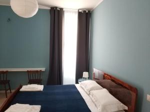 a bedroom with a bed with blue walls and a window at B&B Via Nazionale in Milazzo