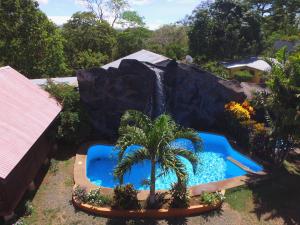 a water park with a fake waterfall and a palm tree at Hotel Cabañas La Teca in Liberia