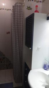cortina de ducha en el baño con lavamanos en Sans Souci, en De Panne