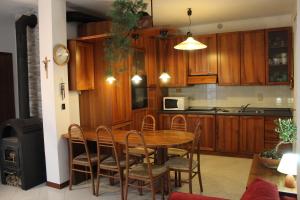 cocina con mesa, sillas y microondas en Residence Villa Cicogna, en Casale sul Sile