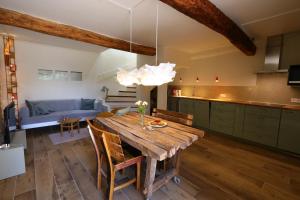 Il comprend une cuisine et une salle à manger avec une table en bois. dans l'établissement Sous le Château, à Rustrel