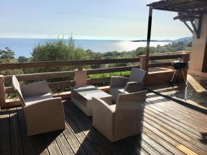 een terras met twee stoelen en een tafel en een parasol bij Residence du valinco Appartement in Olmeto