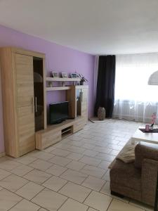 sala de estar con TV y sofá en Ferienwohnung Toge, en Wadgassen