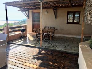 a patio with a table and chairs on a deck at Residence du valinco Appartement in Olmeto +3 photos