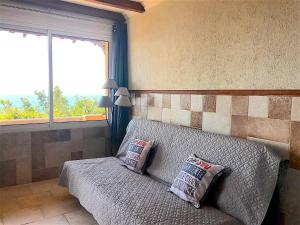 a couch with two pillows in a room with a window at Residence du valinco Appartement in Olmeto