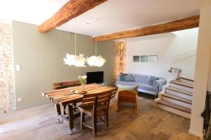 a dining room with a table and a couch at Sous le Château in Rustrel