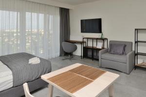 a hotel room with a bed and a chair and a table at Bułgarska 59A- (1/2) piękny widok 14 piętro in Poznań