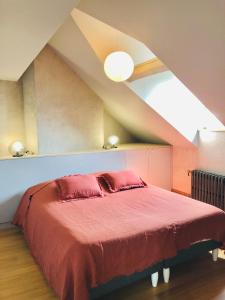 a bedroom with a red bed in an attic at Maison d'architecte en plein cœur d'Honfleur avec bain nordique in Honfleur