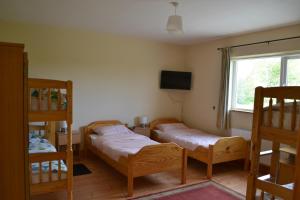 a bedroom with two bunk beds and a television at Sally's Vineyard in Buncrana