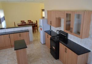 a kitchen with wooden cabinets and a black stove at Chitova’s Guesthouse in Victoria Falls