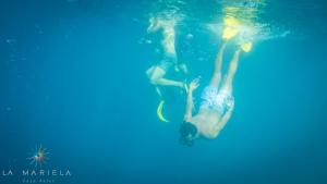 two people are swimming in the water at Casa Hotel La Mariela in Zapzurro